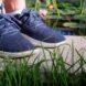 Blue shoes partially obscured by green grass.