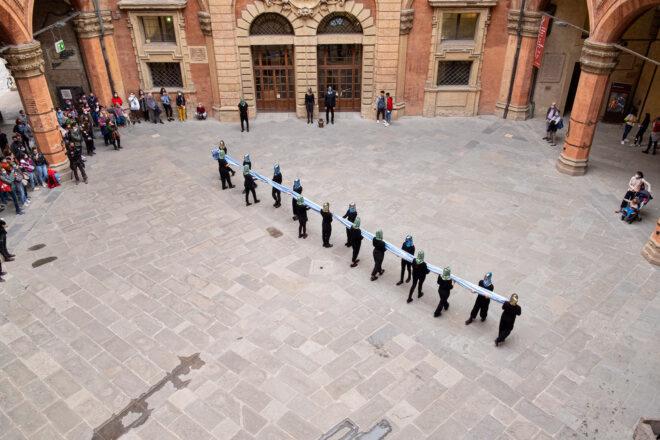 line of people holding blue cloth