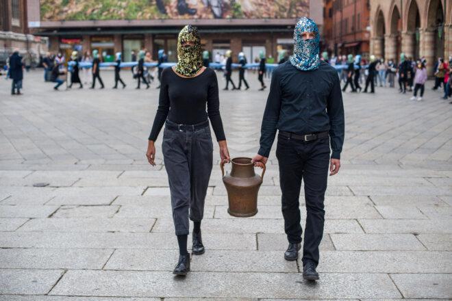 two people carrying a vessel of water