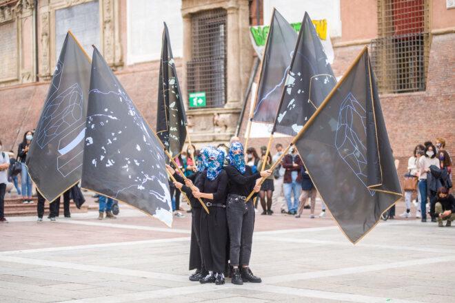 people huddled together and holding flags