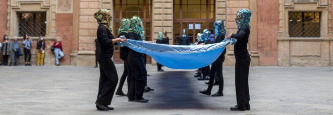 two lines of people holding long blue fabric on each side