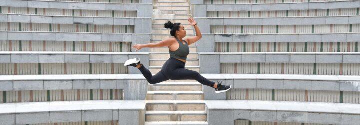 A person jumping while wearing green and black athletic clothes.