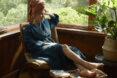 A person lounging in a blue robe.