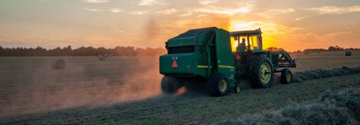 tractor on field at sunset