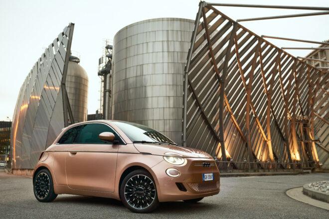 rose gold Fiat in front of metal building