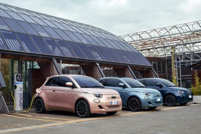 rose gold, gray and black Fiats plugged into electric charging station with solar panels
