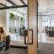 person in meeting room with glass walls and wood door