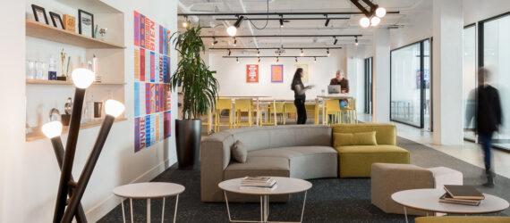 gray and yellow sofa and colorful wall art in an office