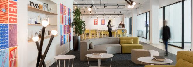 gray and yellow sofa and colorful wall art in an office
