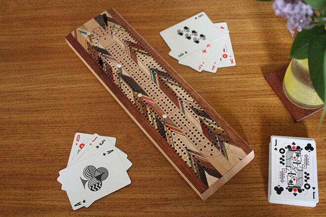 wood cribbage board and cards on wood floor