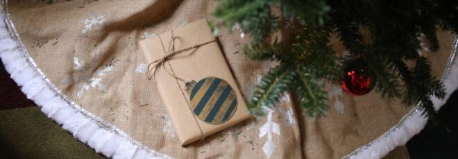 gift wrapped in brown paper placed under a Christmas tree