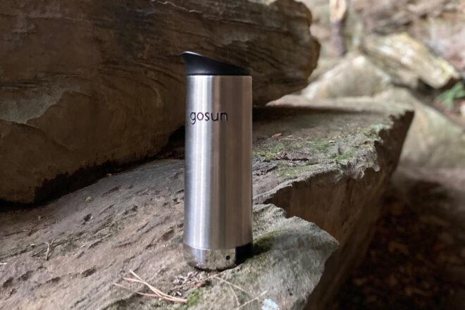 metal travel mug on rock