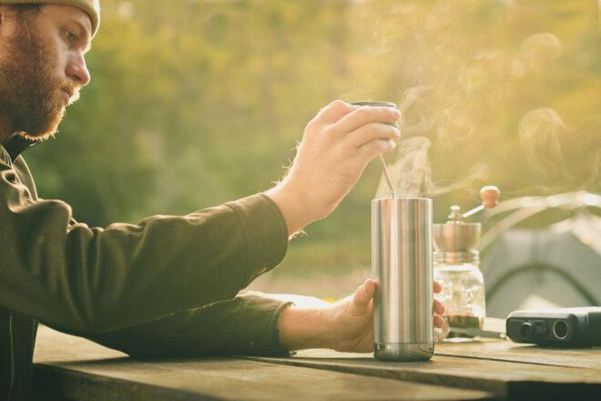 person opening metal travel mug