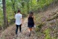 two people walking on forest trail