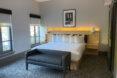 plush hotel bed in white hotel room
