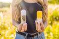 person holding antiperspirant and natural deodorant