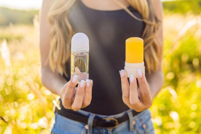 person holding antiperspirant and natural deodorant