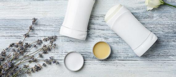 natural deodorant in metal tins next to antiperspirant in plastic containers