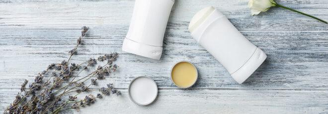 natural deodorant in metal tins next to antiperspirant in plastic containers