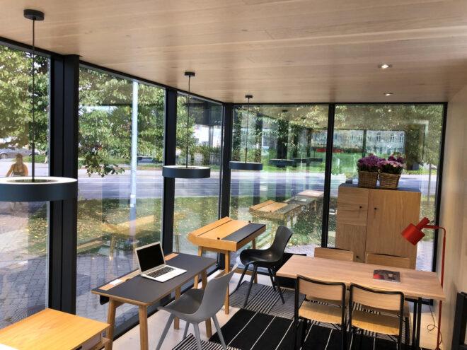 small wood desks in cabin with glass walls