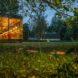 glass cabin with transparent walls lit up at dusk