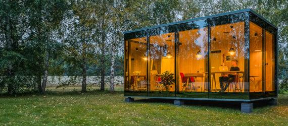 glass cabin with transparent walls lit up at dusk
