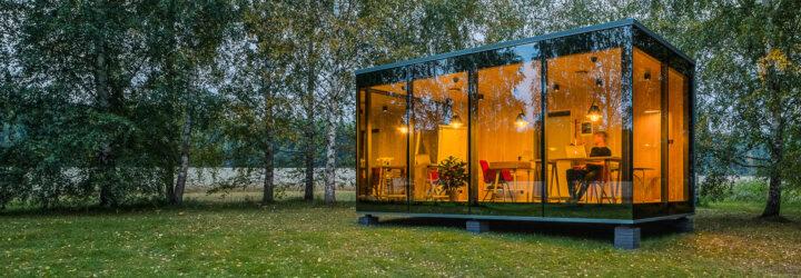 glass cabin with transparent walls lit up at dusk