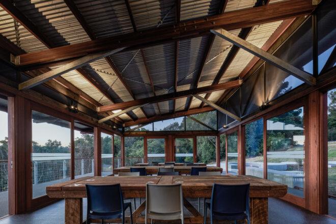 wood tables in room with glass walls and slanted ceiling
