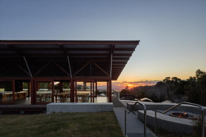 campfire on concrete patio near glass building at sunset