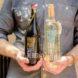 A person holding two bottles of wine.