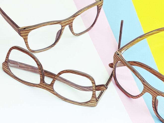 Three pairs of glasses against a white, pink, blue and yellow background.