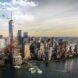 A cityscape with a green campus situated on the water.