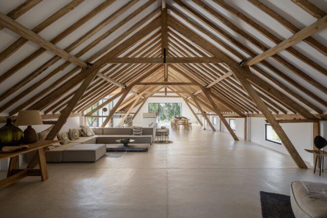 A living room area with sofas and an exposed wood roof truss overhead.