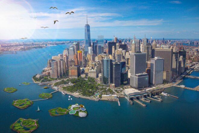 A cityscape with a green campus situated on the water.