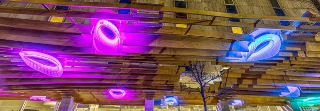 A close-up of a purple lights on a wood canopy.