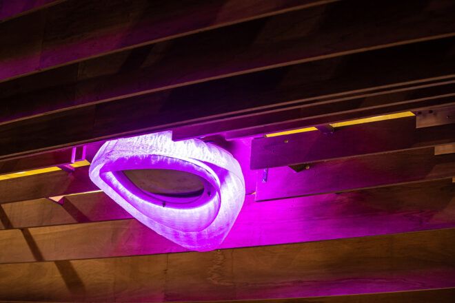 A close-up of a purple light on a wood canopy.