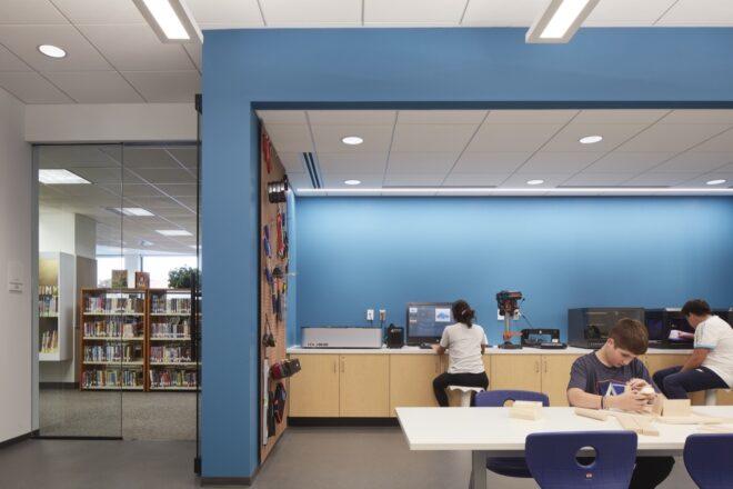 blue classroom with work tables and computers