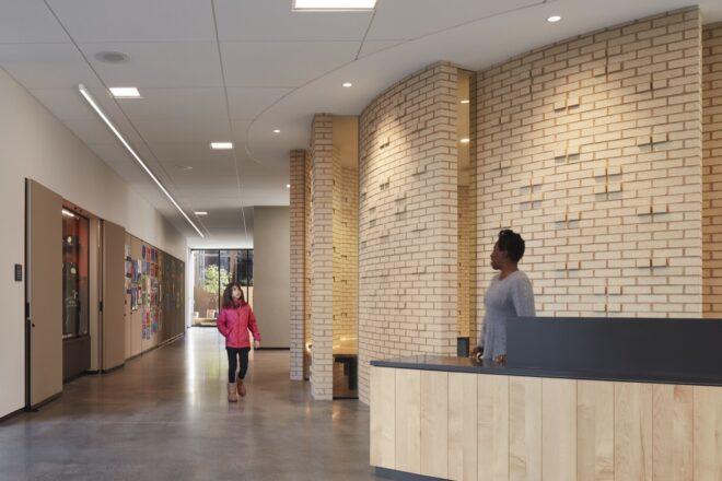 person at wood reception desk