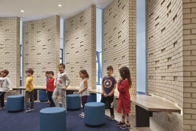 kids standing inside round room with brick walls