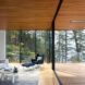blue chair and foot rest near two glass walls leading to wood balcony