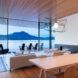 wood dining table near white sofa in room with wood ceiling and glass wall