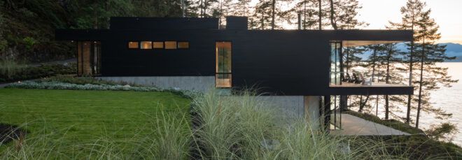 black cabin built into a hillside