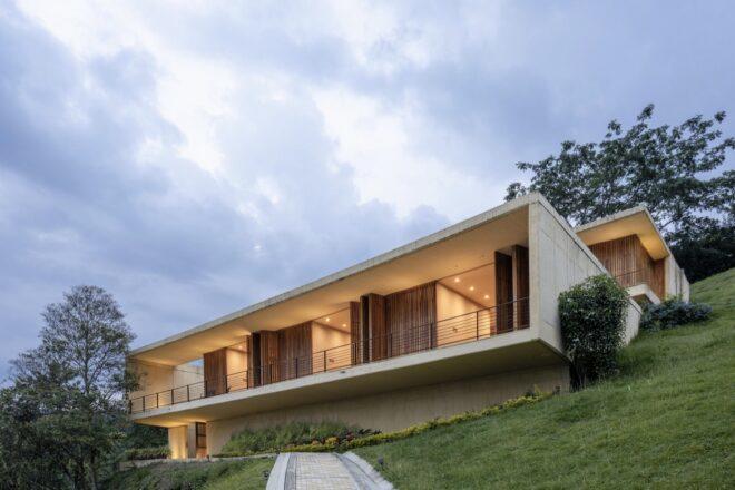 white home with teak screens open across the facade