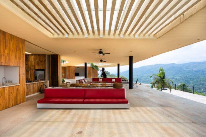 red sofa in wood-lined living room with one wall open to the outdoors