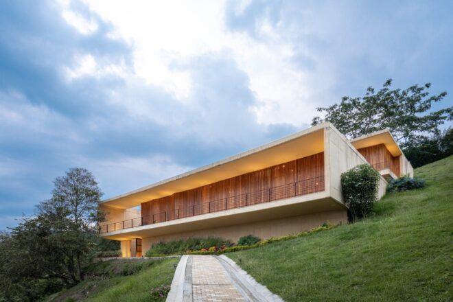 white home with teak screens closed across the facade