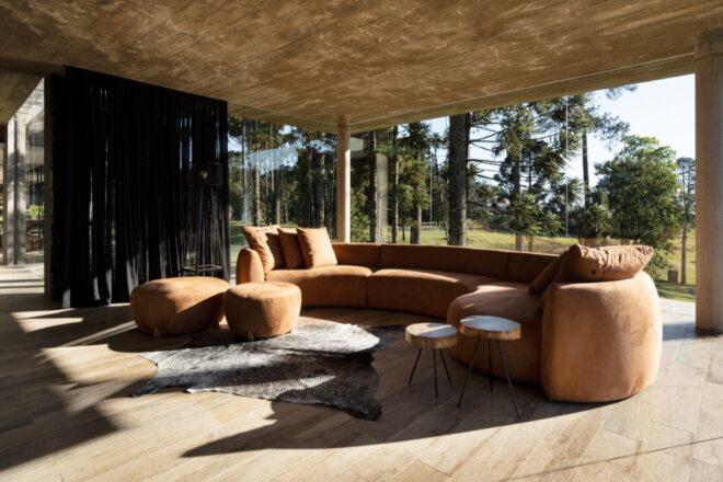 round tan sofa in a large room with glass walls