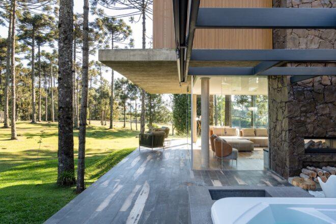 narrow wood patio connected to a room with glass walls