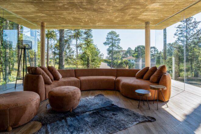 round tan sofa in room with glass walls