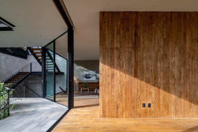 A wood hallway flanked by glass walls on one side.