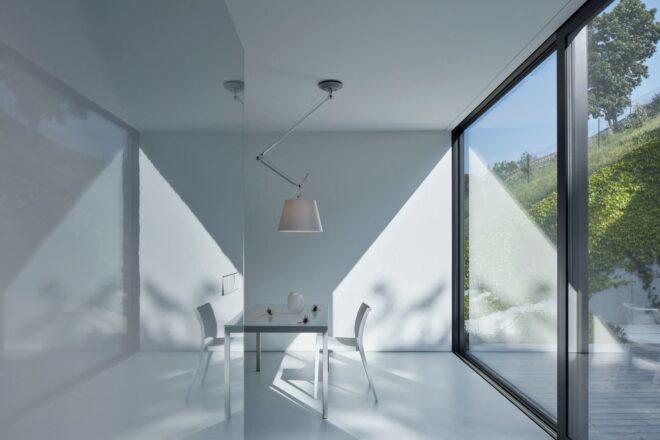white dining table across from a glass wall